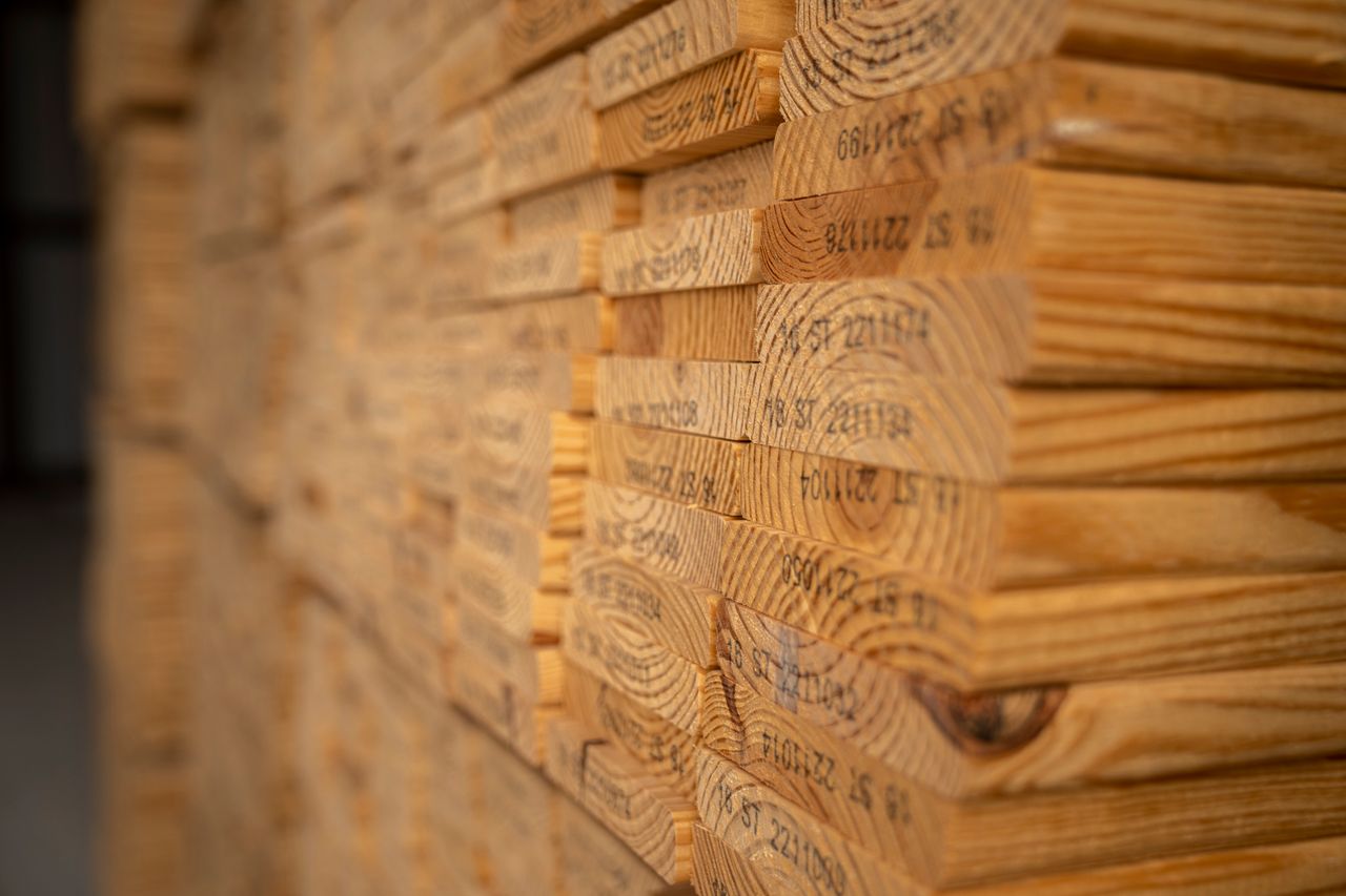 Detailed view of neatly stacked timber planks displaying texture and grain in a warehouse setting.